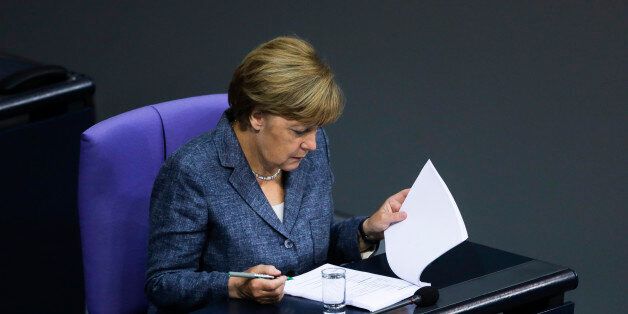 German Chancellor Angela Merkel reads documents as she attends a debate at the German parliament prior to a vote on another bailout package for Greece, in the German Bundestag in Berlin, Wednesday, Aug. 19, 2015. (AP Photo/Markus Schreiber).