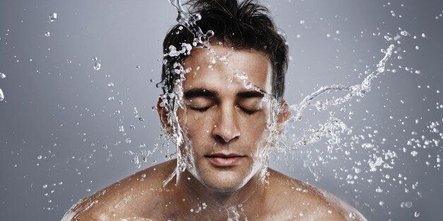 A young man splashing water on his face