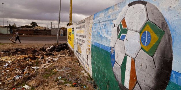 A soccer ball with different colored flags, including the South African national flag, right, painted on a wall in the township of Khayelitsha, South Africa, Thursday, May 28, 2015. The image of South Africaâs 2010 World Cup has been shattered by allegations that its bid over a decade ago was involved in bribes of more than $10 million to secure FIFA votes _ possibly with the knowledge or involvement of the South African government. (AP Photo/Schalk van Zuydam)