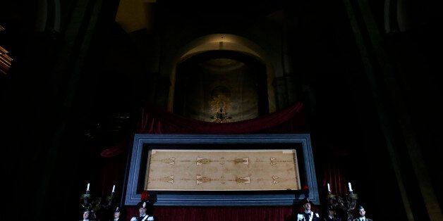 The Holy Shroud, the 14 foot-long linen revered by some as the burial cloth of Jesus, is on display at the Cathedral of Turin, Italy, Saturday, April 18, 2015. The long linen with the faded image of a bearded man, that is the object of centuries-old fascination and wonderment, will be on display for the public from April 19 to June 24, 2015. Pope Francis said he is planning to visit the Holy Shroud during a a pilgrimage to Turin next June 21, 2015. (AP Photo/Antonio Calanni)