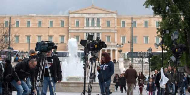 ATHENS, GREECE - JANUARY 25: Media crew set up in front of the Greek Parliament building on January 25, 2015 in Athens, Greece. According to the latest opinion polls, the left-wing Syriza party are poised to defeat Prime Minister Antonis Samaras' conservative New Democracy party in the election, which will take place today. European leaders fear that Greece could abandon the Euro, write off some of its national debt and put an end to the country's austerity by renegotiating the terms of its bai