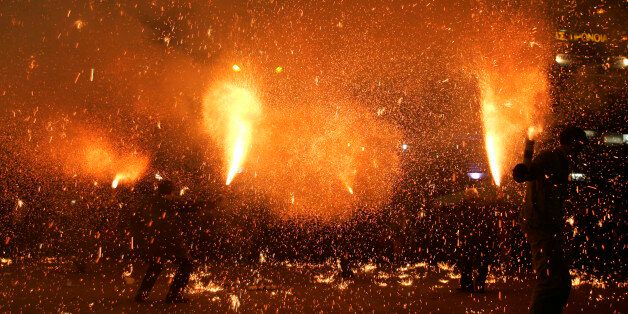 Revelers hold flares during pre-Easter celebrations in the city of Agrinio, western Greece, late Good Friday, April 25, 2008. The celebration, known as 'saitopolemos' in Greek, dates back to Greece's 1821-32 war of independence against the Ottoman Empire. (AP Photo/Petros Giannakouris)