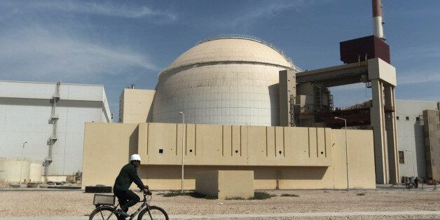 FILE - In this Oct. 26, 2010 file photo, a worker rides a bicycle in front of the reactor building of the Bushehr nuclear power plant, just outside the southern city of Bushehr, Iran. Assassinations, cyber-attacks and possible military strikes: As nuclear negotiations with Iran enter a crucial stage, Tehran is voicing fears that tougher oversight of its activities will increase the risks of an attack on its atomic facilities and the scientists working on them. (AP Photo/Mehr News Agency, Majid Asgaripour, File)