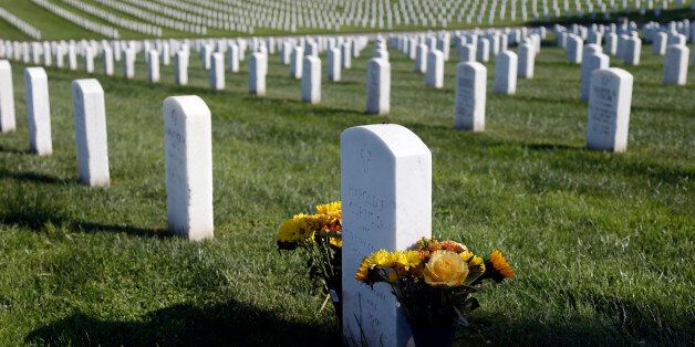 Flowers are placed over a war veteran's tombstone at Golden Gate National Cemetery on Monday, Nov. 10, 2014, in San Bruno, Calif. The U.S. celebrates Veterans Day Tuesday in honor of those who have served in the nation's military. (AP Photo/Marcio Jose Sanchez)