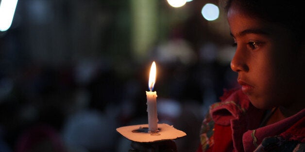 LAHORE, PUNJAB, PAKISTAN - 2015/04/05: Pakistani Christian worshipers pray and hold candles during an Easter vigil mass at the church in Regal Church, Lahore. Christians around the world are marking of Easter Sunday during Holy Week were Christians observed and celebrated the Easter with special Easter vigil mass prayer ceremonies across Lahore on Sunday. (Photo by Rana Sajid Hussain/Pacific Press/LightRocket via Getty Images)