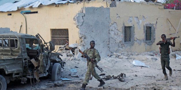 Somali soldiers take position after a bomb that was detonated at the gate of one of Mogadishu's most popular hotel. Friday, March, 27, 2015, A Somali police official says a suicide bomber has detonated his explosives-laden car at the gate of a hotel popular with government officials in Mogadishu. Capt. Mohamed Hussein says gunfire could be heard inside the Maka-Mukarramah Hotel, but it was not clear if any gunmen had managed to penetrate the hotel's gate( AP P hoto/Farah Abdi Warsameh)