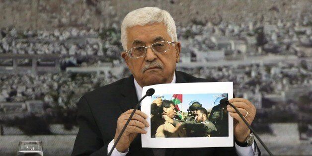 Palestinian President Mahmoud Abbas holds up a picture of senior Palestinian offical Ziad Abu Ein a in a confrontation with an Israeli security member during a leadership meeting in the West Bank city of Ramallah on December 10, 2014. President Abbas said all options were open for a Palestinian response to the death of Abu Ein after his confrontation with Israeli troops. AFP PHOTO / ABBAS MOMANI (Photo credit should read ABBAS MOMANI/AFP/Getty Images)