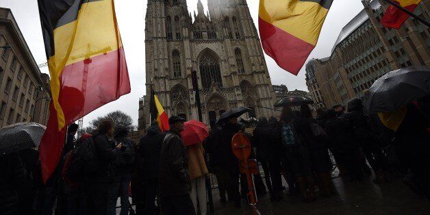 Onlookers wave Belgium flags as the coffin arrives during the funeral of late Belgium Queen Fabiola of Belgium at the Saint Michael and Saint Gudula Cathedral in Brussels on December 12, 2014. Queen Fabiola de Mora y Aragon, widow of Belgian King Baudouin, passed away on December 5 at the age of 86. AFP PHOTO / EMMANUEL DUNAND (Photo credit should read EMMANUEL DUNAND/AFP/Getty Images)