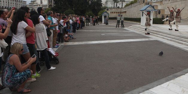 ATHENS, GREECE - OCTOBER 6 : Tourists take photo as Evzone soldiers march outside Greek parliament and the Tomb of the Unknown Soldier during the change of guard in Athens, Greece on October 6, 2014. Although all Greek men are required to serve in the military, only the highest caliber who meet the specific height, weight, and physical requirements are selected to serve as Evzones. (Photo by Ayhan Mehmet/Anadolu Agency/Getty Images)