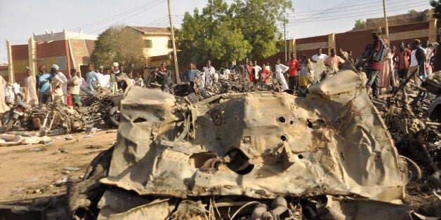 People gather at the site of a bomb explosion in Kano, Nigeria, Friday Nov. 28, 2014. An explosion tore through the central mosque in Nigeria's second-largest city on Friday, and officials feared the casualty toll would be high. Capt. Ikechukwu Eze said the Friday blast occurred at the main mosque in the city of Kano. Hundreds had gathered to listen to a sermon in a region terrorized by attacks from the militant group Boko Haram. (AP Photo/Muhammed Giginyu)