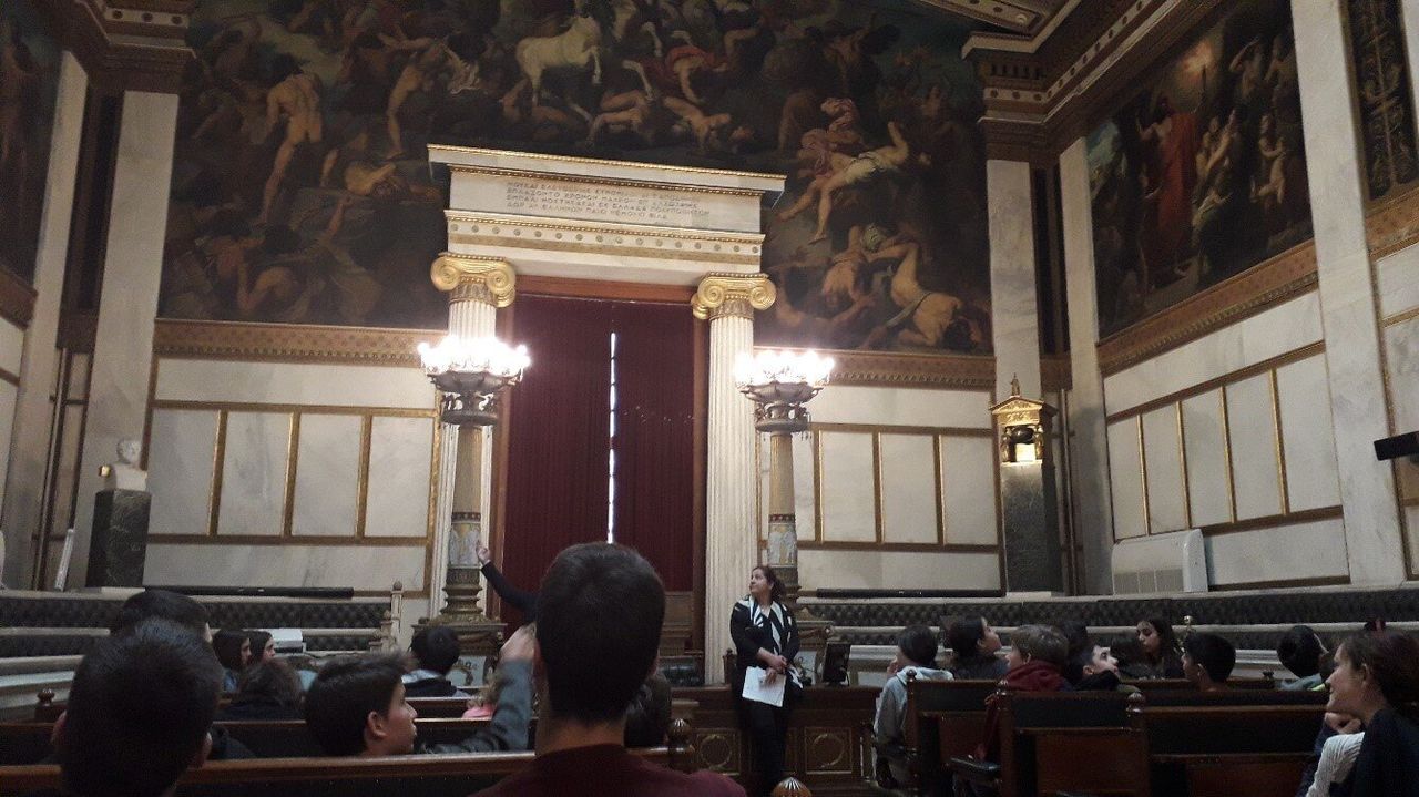 Η Αίθουσα τις Ολομέλειας, με τα έδρανα και τον εξαιρετικό ζωγραφικό διάκοσμο. Στα δεξιά διακρίνεται η απεικόνιση του Προμηθέα την στιγμή που χαρίζει στους ανθρώπους την φωτιά.