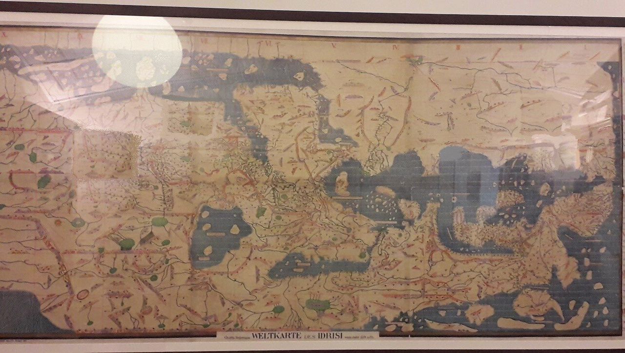 Ο Παγκόσμιος Χάρτης του τότε γνωστού κόσμου του διάσημου Άραβα Χαρτογράφου Al-Idrisi (12ος αιώνας) όπως αυτός βρίσκεται αναρτημένος στο χώρο του Αναγνωστηρίου της Βιβλιοθήκης. Ο Χάρτης έχει σχεδιαστεί με ανάποδο προσανατολισμό συγκριτικά με τους σημερινούς χάρτες, δηλαδή ο Νότος είναι στην κορυφή του χάρτη και όχι ο Βορράς. Η Αραβική χερσόνησος δεσπόζει στο πάνω κέντρο του χάρτη. Δεξιά και κάτω διακρίνεται η «ανάποδη» Ευρώπη. Ο χάρτης καλύπτει περιοχές εκτός της Ευρώπης η οποία απεικονίζεται κάτω δεξιά, καθώς ο Al-Idrisi ως κάτοικος μουσουλμανικού - αραβικού κράτους, είχε πρόσβαση σε περιοχές όπως η Αραβική Χερσόνησος, η Δυτική Αφρική, η Ινδία, η Κίνα και η Κεντρική Ασία. 