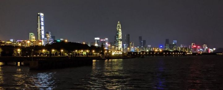 The Shenzhen skyline at night. The building in the center has projected text that reads “天佑武汉" (God bless Wuhan).