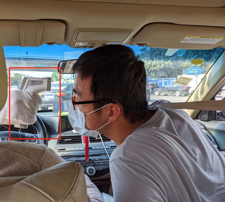 Harry on the receiving end of a thermometer gun at a highway toll booth.