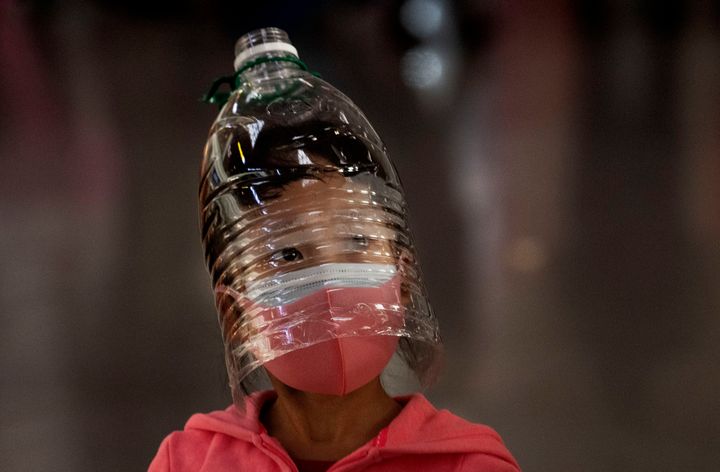 Ένα κορίτσι το Πεκίνο φορά όχι μόνο μάσκα αλλά και ένα πλαστικό μπουκάλι στο κεφάλι ελπίζοντας να προστατευθεί επαρκέστερα από τον κορονοϊό (30/01/2020).