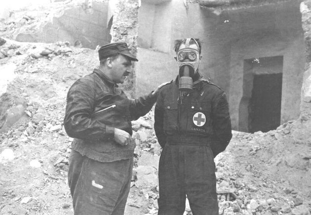Haldane with a volunteer, demonstrating a gas mask in Spain, c. 1936-37, Source: Imperial War