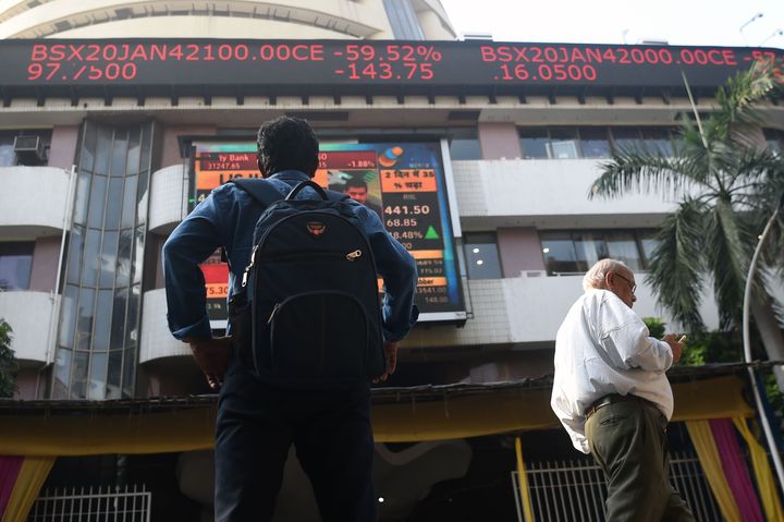 A man watches share prices on a digital broadcast outside the Bombay Stock Exchange (BSE) in Mumbai on January 6, 2020. (Photo by Punit PARANJPE / AFP) (Photo by PUNIT PARANJPE/AFP via Getty Images)