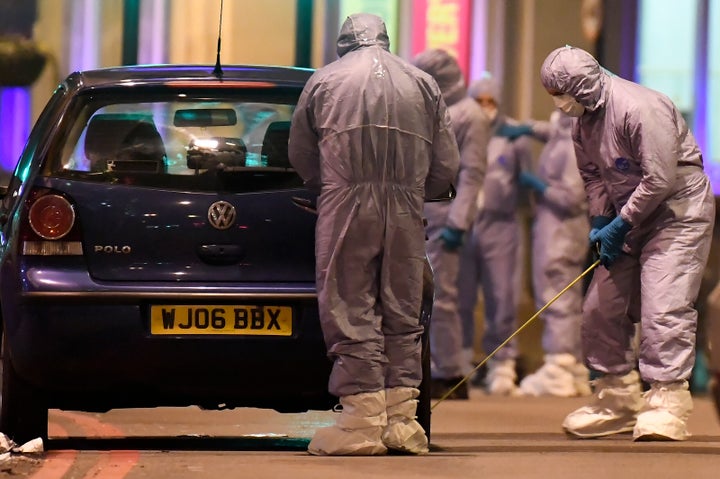 Police forensic officers work near a car at the scene after a stabbing incident in Streatham, London, on Sunday.