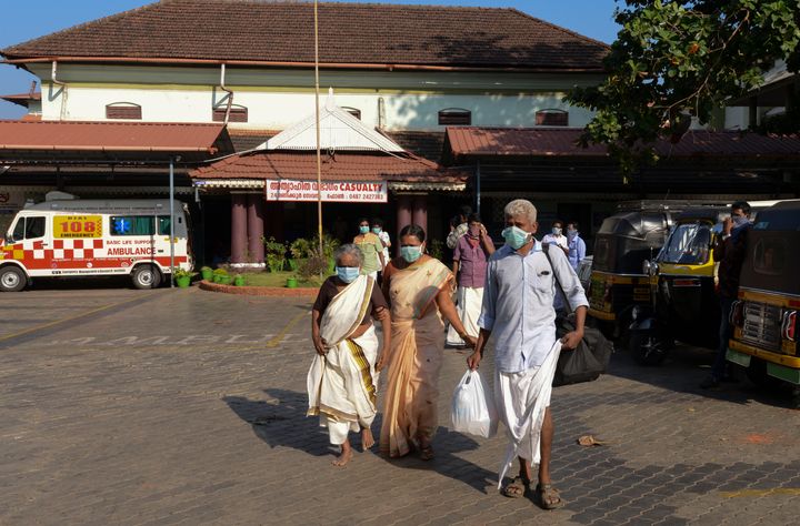 People wearing surgical masks walk out of the government general hospital where a student who had been in Wuhan is kept in isolation in Thrissur, Kerala, Jan. 30, 2020. 