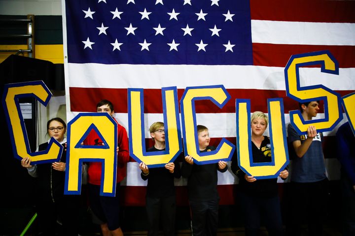 Attendees hold letters that read "CAUCUS" during a campaign event for Democratic presidential candidate Pete Buttigieg at Northwest Junior High in Coralville, Iowa on Sunday. (AP Photo/Matt Rourke)