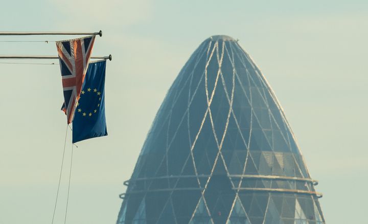 A Union Flag and a European Union flag seen alongside 30 St Mary Axe, also known as the Gherkin, in the City financial district of central London