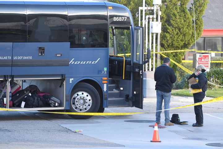 Investigators are seen outside of a Greyhound bus after a passenger was killed on board early Monday.