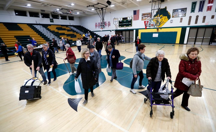 Des Moines residents enter a caucus site at Hoover High School on Monday.