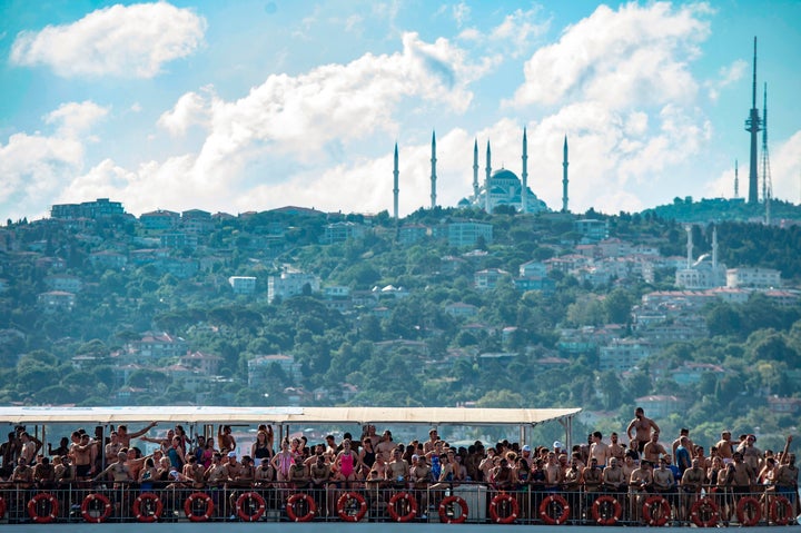 A ferry boat carries swimmers to the start point along the Bosphorous river before taking part in the Bosphorus Cross Continental Swim event on July 21, 2019 in Istanbul. - The race takes some 2,400 participants 6 kms down the Bosphorus Strait from the Asian side of Istanbul to the European side. (Photo by Yasin AKGUL / AFP) (Photo credit should read YASIN AKGUL/AFP via Getty Images)