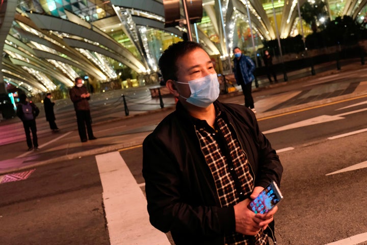 A man wearing mask walks in front of Casino Lisboa, before its temporary closing, following the coronavirus outbreak in Macau, China February 4, 2020. REUTERS/Tyrone Siu