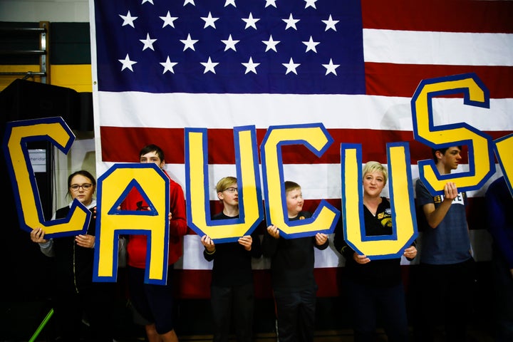 Attendees hold letters that read "CAUCUS" during a campaign event for Democratic presidential candidate Pete Buttigieg on Feb. 2, 2020, in Coralville, Iowa.