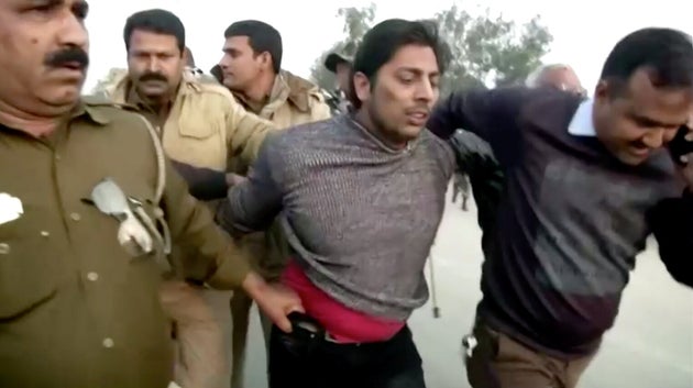 Police officers detain  Kapil Gujjar, who fired multiple shots in New Delhi's Shaheen Bagh where...