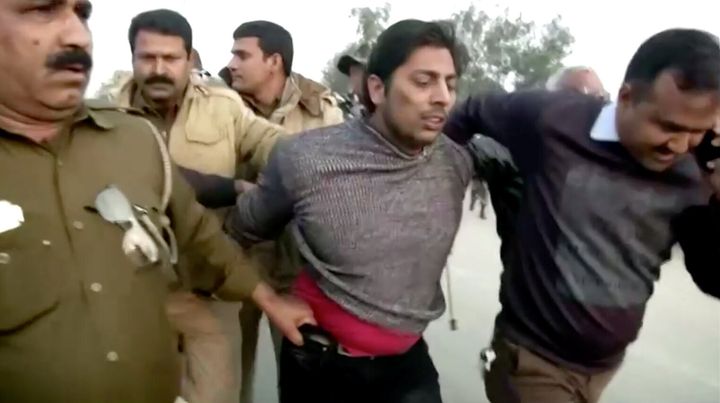 Police officers detain Kapil Gujjar, who fired multiple shots in New Delhi's Shaheen Bagh where people have been protesting against the Citizenship Amendment Act since December 15. 