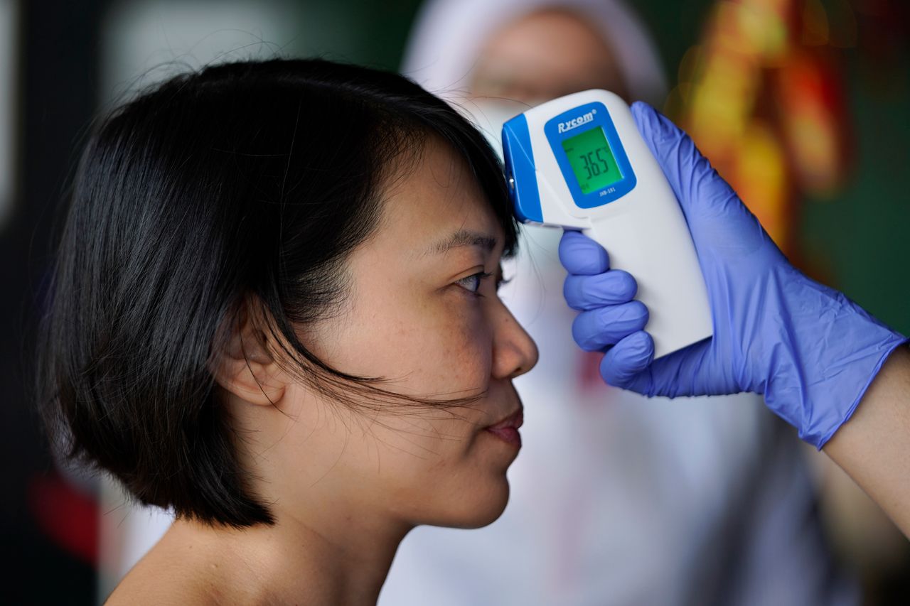 Νοσοκόμα προχωρά σε θερμομέτρηση ταξιδιώτη σε νοσοκομείο στην Κουάλα Λουμπούρ της Μαλαισίας (5 Φεβρουαρίου)