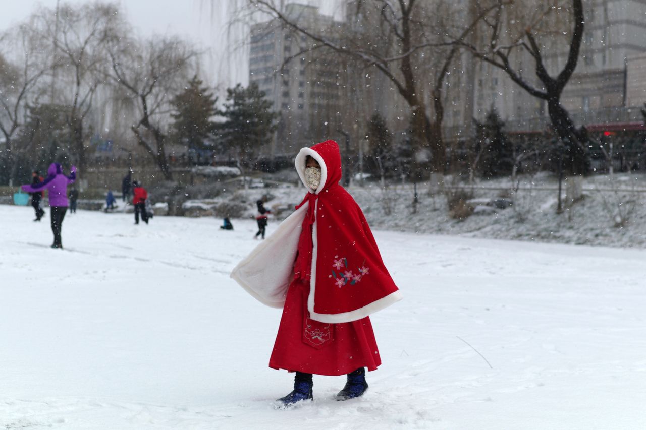 Ένα κορίτσι ντυμένο σαν κοκκινοσκουφίτσα, περπατά σε πάρκο στο Πεκίνο. Φυσικά φορά προστατευτική μάσκα (5 Φεβρουαρίου). 