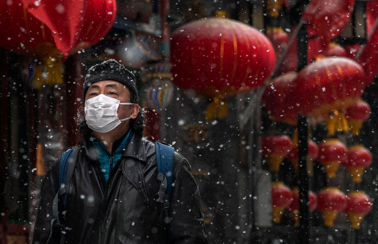 Ένας άνδρας με προστατευτική μάσκα περπατά σε εμπορικό δρόμο του Πεκίνου (5 Φεβρουαρίου)