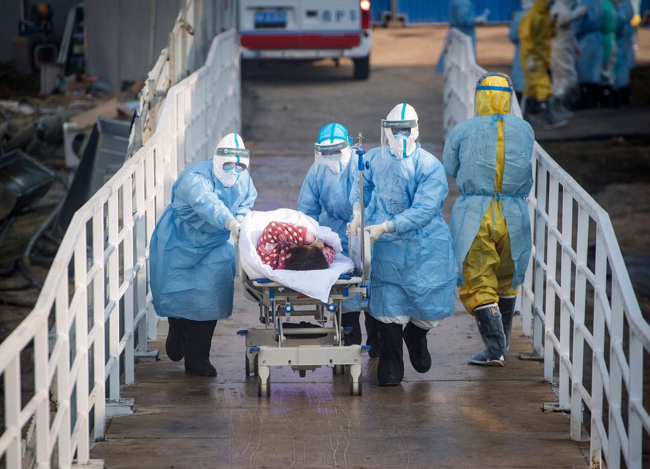 Medical workers in protective suits help transfer the first group of patients into the newly-completed Huoshenshan temporary field hospital in Wuhan