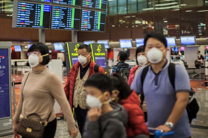 Mία οικογένεια «πάνοπλη» με μάσκες στα πρόσωπα, ετοιμάζεται να ταξιδέψει στο διεθνές αεροδρόμιο της Σιγκαπούρης. Ιανουάριος 2020. (Photo by Maverick Asio/SOPA Images/LightRocket via Getty Images)