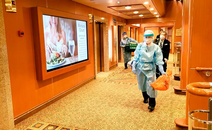 Medical workers in protective gear walk on the cruise ship Diamond Princess in this Feb. 4 photo taken by a passenger.