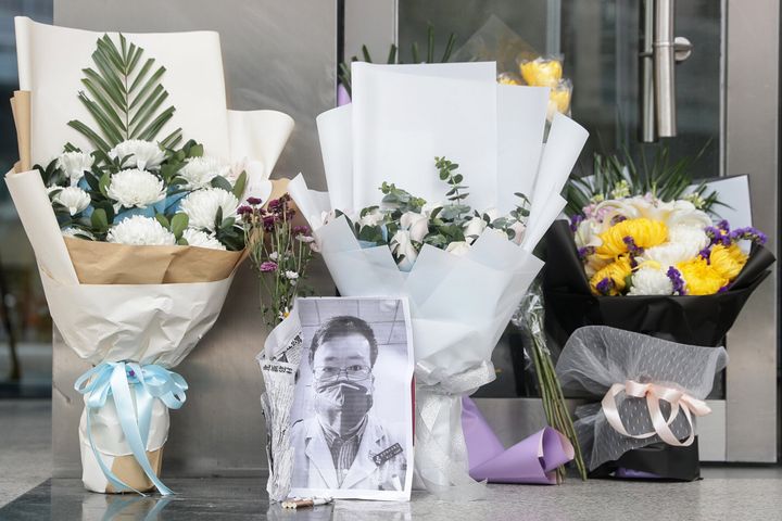 A photo of Li Wenliang is seen with flower bouquets at Wuhan Central Hospital 