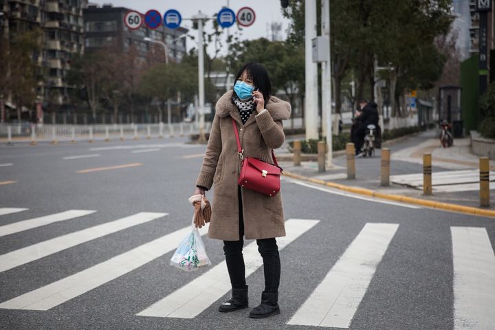 A woman wears a protective mask as she walks in the street on Saturday, Feb. 1, 2020 in Wuhan.