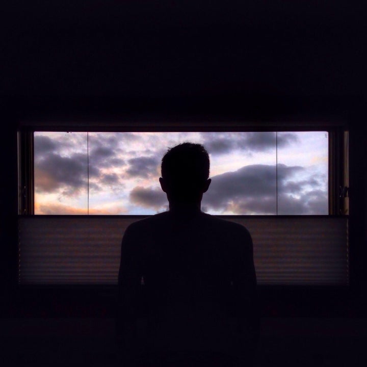 Un hombre junto a una ventana.