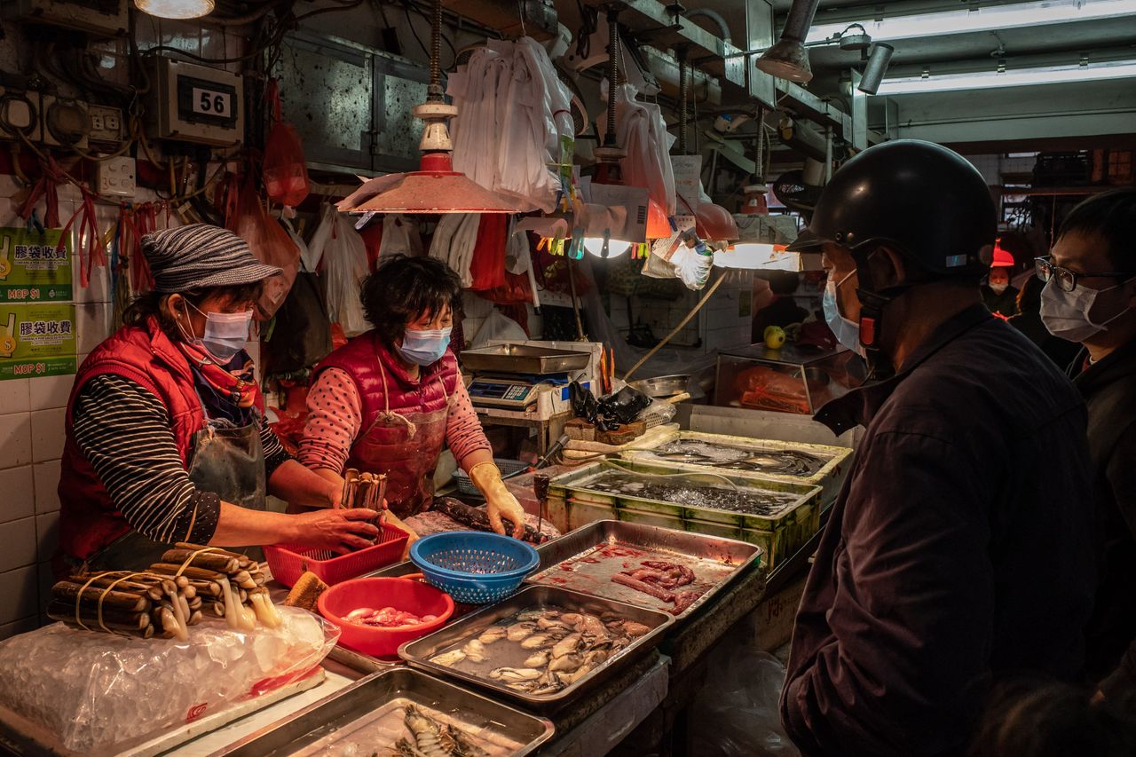 Shoppers wearing face masks purchase seafood at a market on Jan. 28, 2020, in Macau, China.