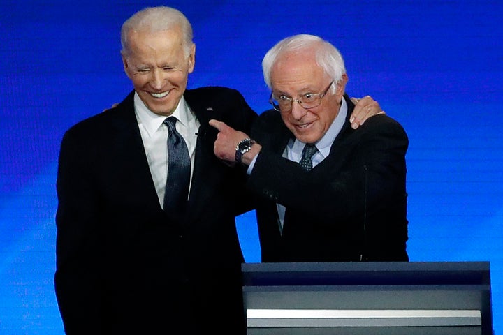 Former Vice President Joe Biden, left, embraces Sen. Bernie Sanders (I-Vt.) during the Democratic presidential primary debate Friday at St. Anselm College in Manchester, New Hampshire.