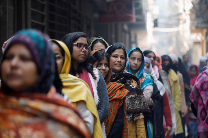 Voters stand in a queue as they wait to cast their vote outside a polling booth during the state assembly election, in Shaheen Bagh, New Delhi, February 8, 2020. 