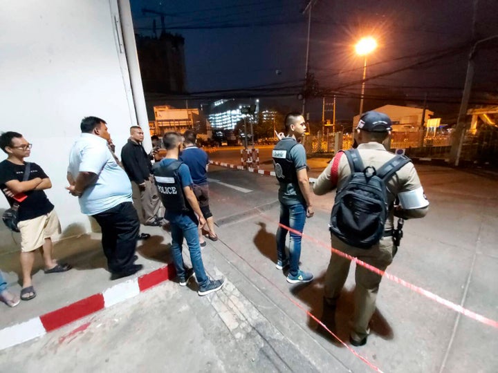 Police and bystanders stand near the scene of a shooting at the Terminal 21 mall, in Korat, Thailand, Saturday, Feb. 8, 2020. Police in northeastern Thailand said a soldier shot multiple people on Saturday, killing more than 10, and was holed up at a popular shopping mall. (AP Photo)