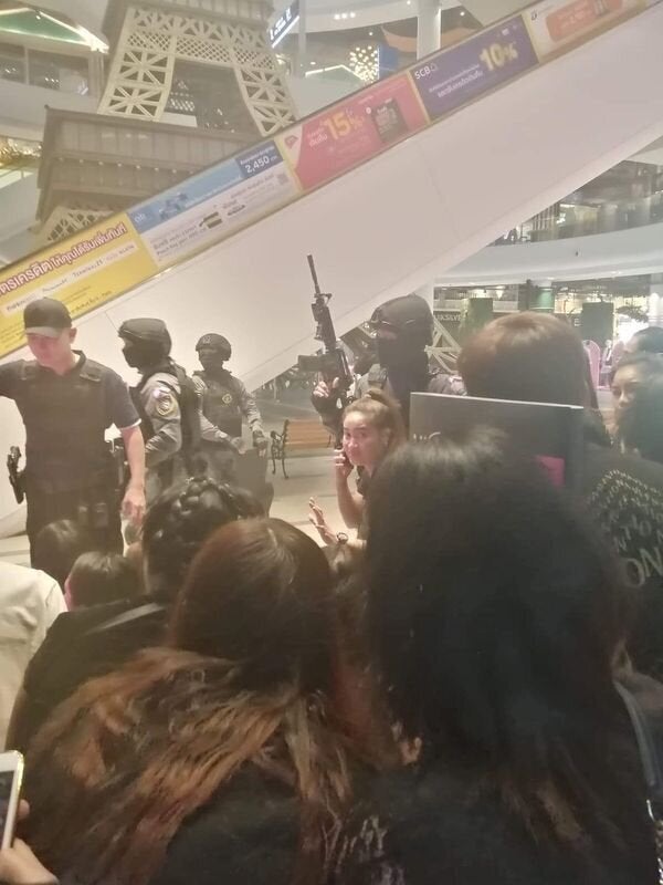 People are evacuated from a shopping mall by members of security forces after a shooting rampage in the city of Nakhon Ratchasima