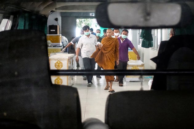 A buddhist monk and rescue workers carry a body of a victim of a gun battle involving a Thai soldier on a shooting rampage at a hospital, in Nakhon Ratchasima, Thailand, February 9, 2020. REUTERS/Athit Perawongmetha