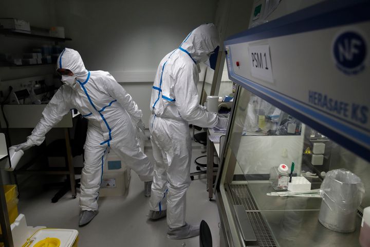Γάλλοι επιστήμονες εξετάζουν στο εργαστήριο δείγματα κορονοϊού. 