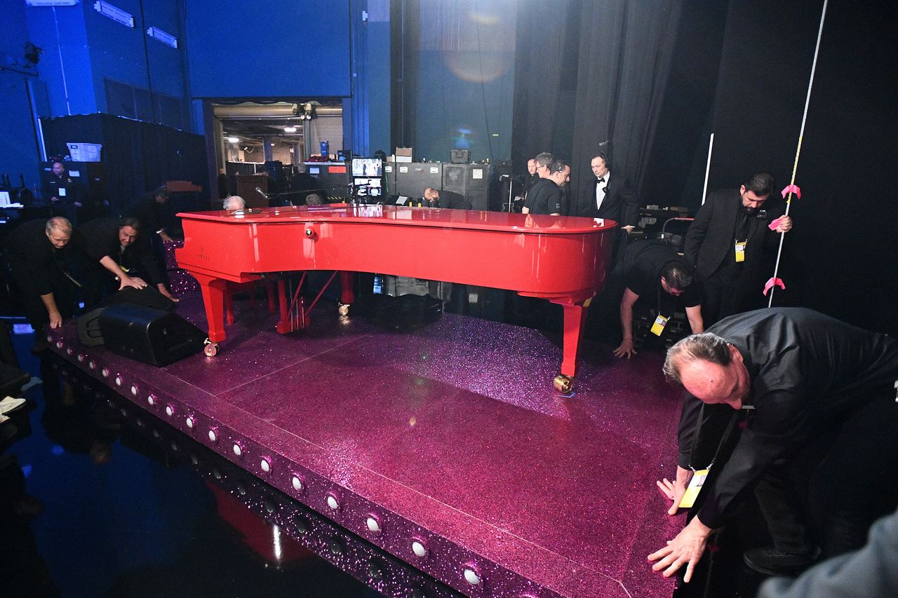 Οι τεχνικοί ετοιμάζουν το κόκκινο πιάνο του «Rocketman» Έλτον Τζον, ενώ ετοιμάζεται να ερμηνεύσει live το «(I'm Gonna) Love Me Again», που τιμήθηκε με το Όσκαρ Τραγουδιού. 