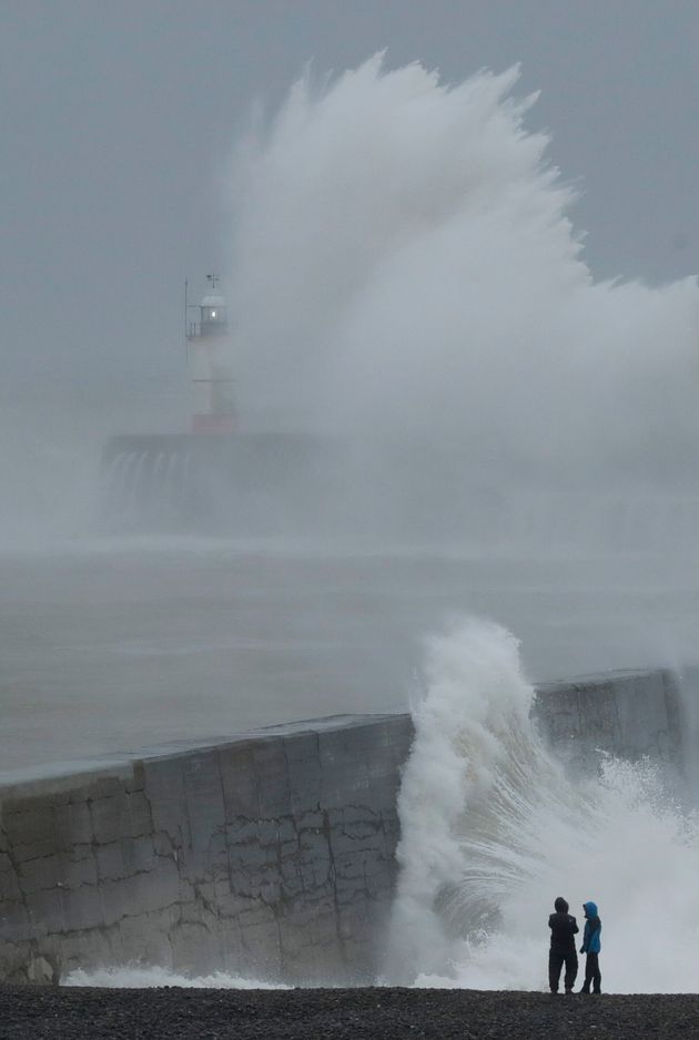 Waves crash over the harbour wall by a lighthouse as Storm Ciara hits Newhaven, on the south coast of England on Sunday 